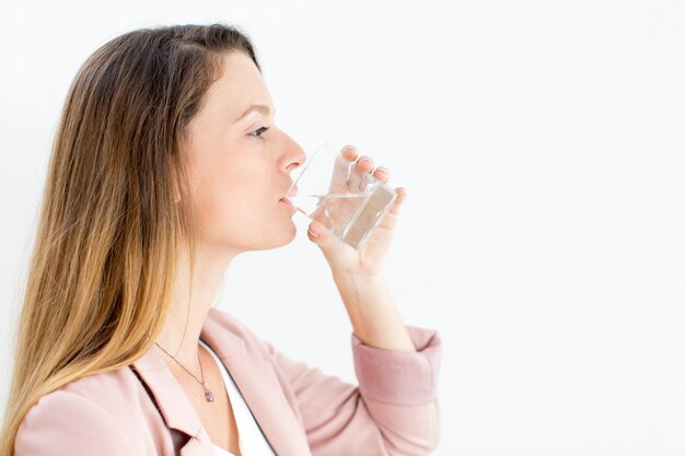 Confident young businesswoman drinking water