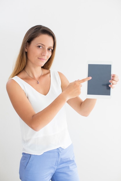 Confident young businesswoman pointing at touchpad