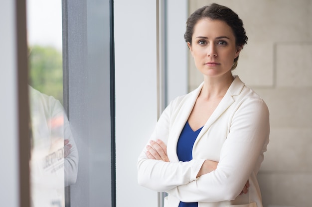 Free photo confident young businesswoman with folded arms