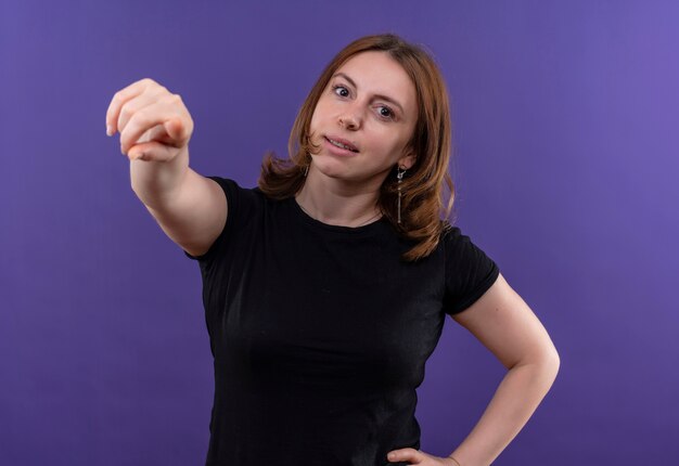 Confident young casual woman pointing  on isolated purple space