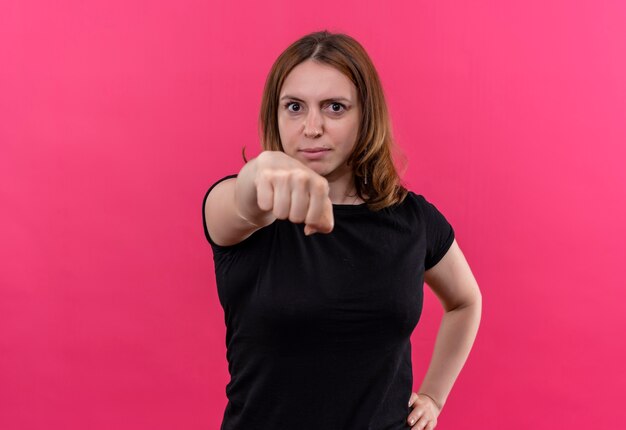 Confident young casual woman stretching out fist  on isolated pink space with copy space