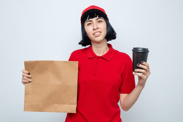 Confident young caucasian delivery woman holding food bag and paper cup