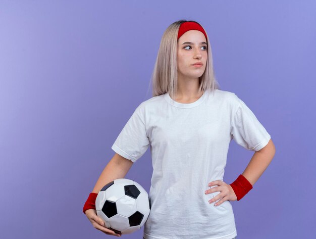 Confident young caucasian sporty girl with braces wearing headband