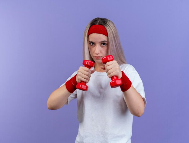 Confident young caucasian sporty girl with braces wearing headband