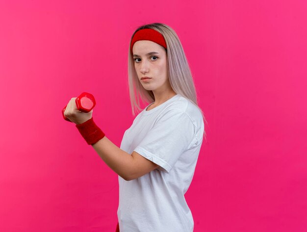 Confident young caucasian sporty girl with braces wearing headband