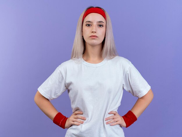 Confident young caucasian sporty girl with braces wearing headband