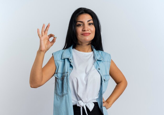 Уверенная молодая кавказская женщина жестами показывает знак рукой