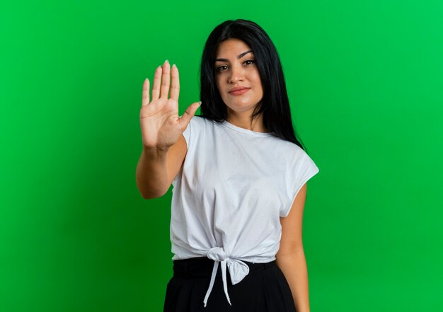 Confident young caucasian woman gestures stop hand sign