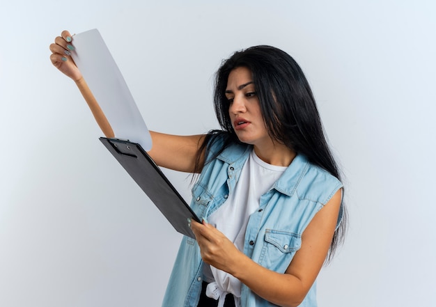 Confident young caucasian woman holds and looks at clipboard