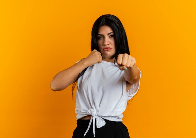 Confident young caucasian woman keeps fists ready to punch