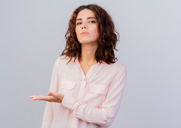 Confident young caucasian woman points at side with hand