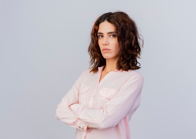 Confident young caucasian woman stands with crossed arms