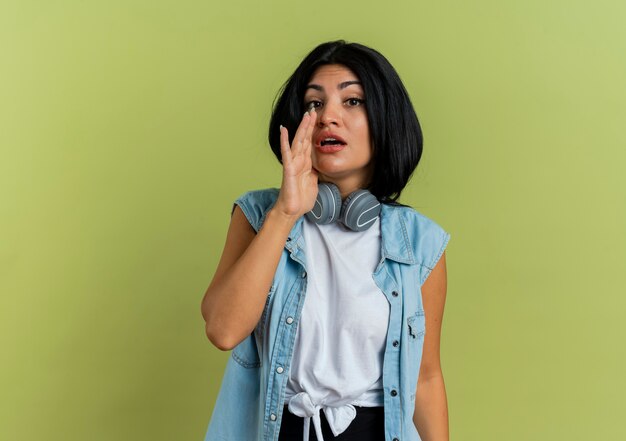 Confident young caucasian woman with headphones calling someone