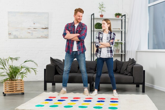 カラードットゲームで遊ぶソファーの前で自信を持って若いカップル立って