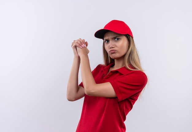 Confident young delivery girl wearing red uniform and cap -showing handshakes gesture isolated on white wall