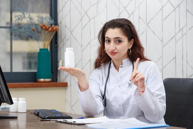 Confident young doctor holding drug capsule and gesture NO High quality photo