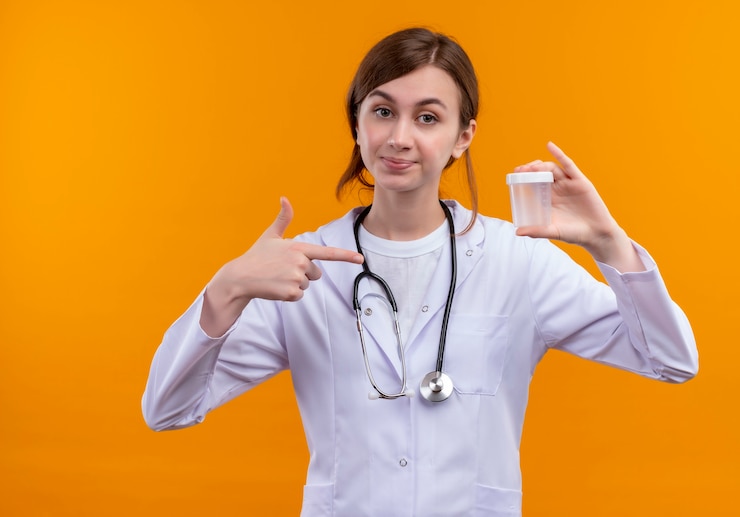 Free Photo confident young female doctor wearing medical robe and stethoscope holding beaker and pointing at it on isolated orange space