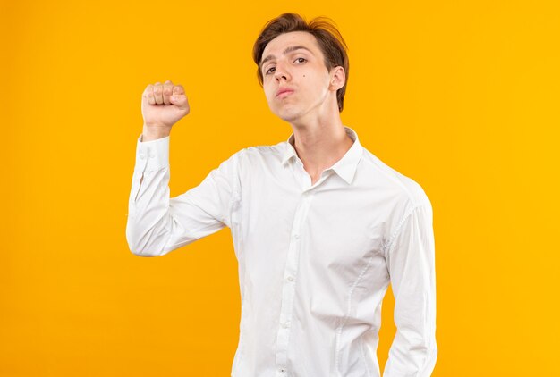 Confident young handsome guy wearing white shirt doing strong gesture isolated on orange wall