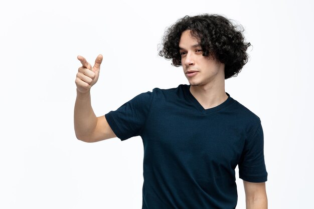 Confident young handsome man looking and pointing at side isolated on white background