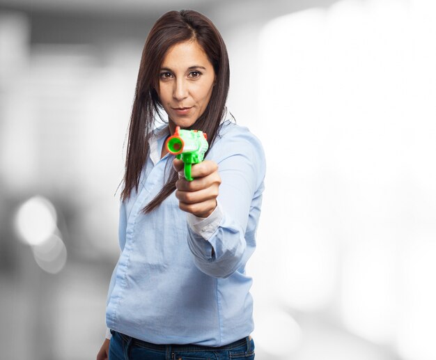 Confident young lady holding a plastic gun