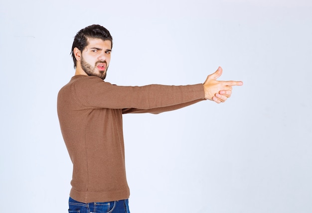 Free photo confident young making shooting gesture like secret agent.