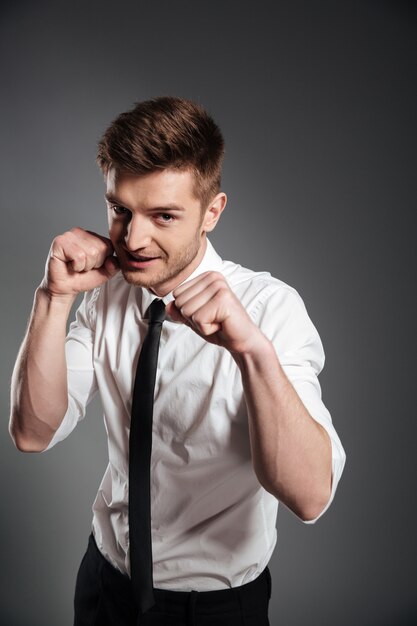 Confident young man in formalwear boxing