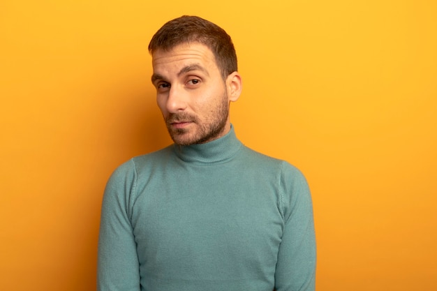 Confident young man looking at front isolated on orange wall