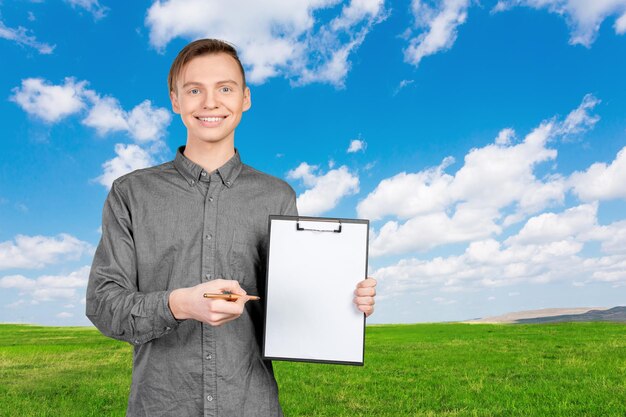 Confident young man in shirt making notes in his pad