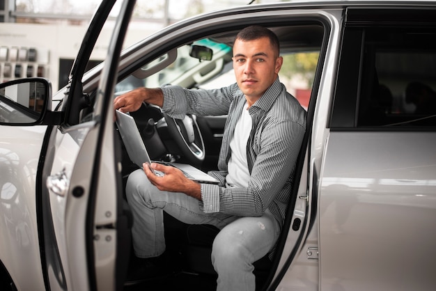 Confident young man testing a car