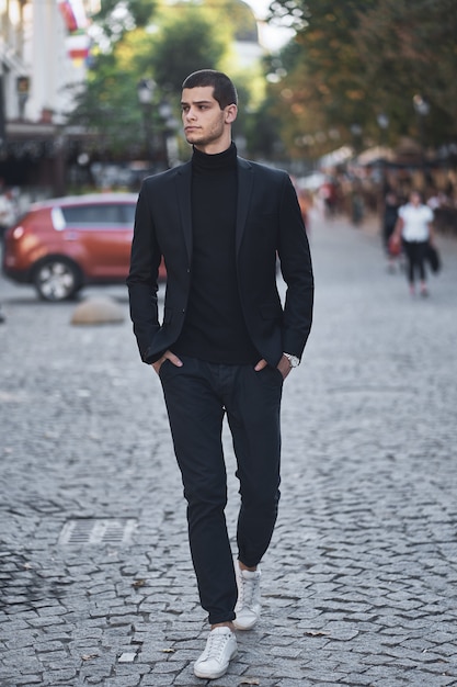 Free photo confident young man walking on a european city street