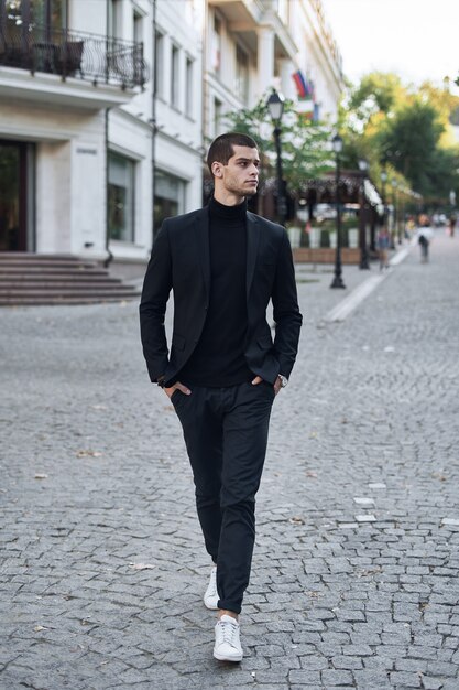 Уверенный молодой человек, идущий по европейской городской улице