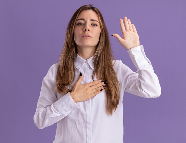 Foto gratuita fiduciosa giovane ragazza abbastanza caucasica che fa il gesto del giuramento