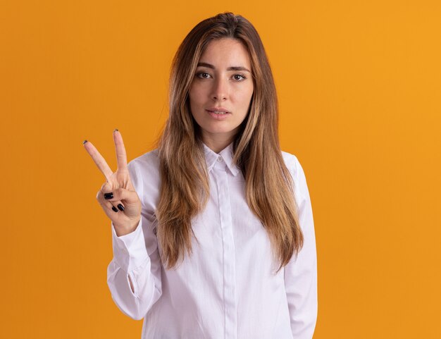 Confident young pretty caucasian girl gestures victory hand sign