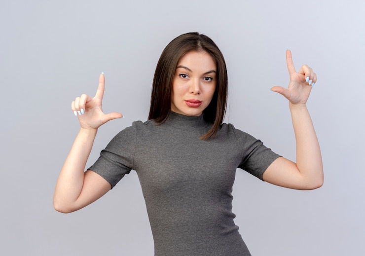 無料Photo 白い背景で隔離の敗者のジェスチャーをしている自信を持って若いきれいな女性