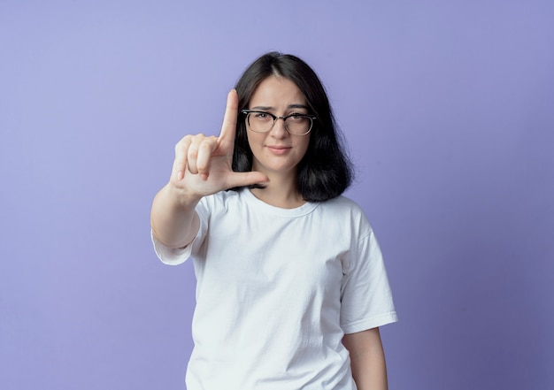confident young pretty woman wearing glasses doing loser gesture at front