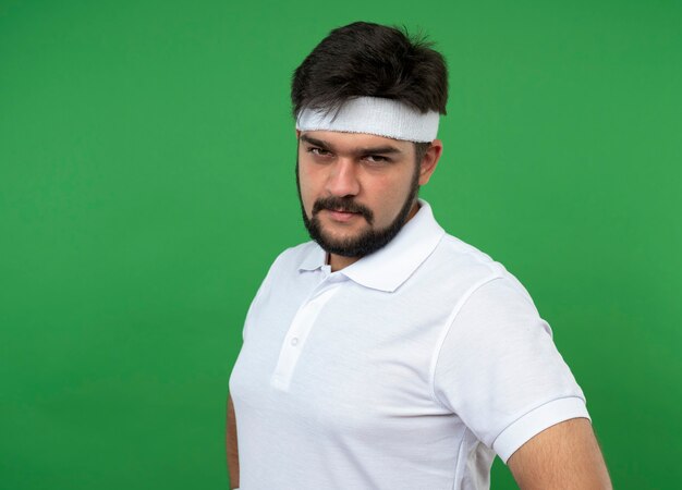 Confident young sporty man wearing headband and wristband