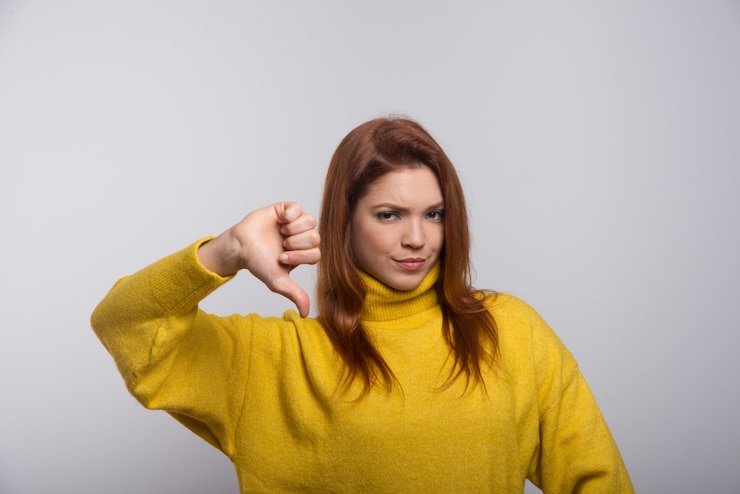 Free Photo confident young woman showing thumb down