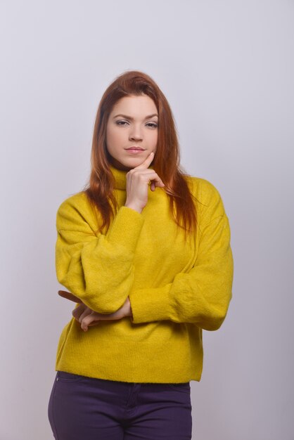 Confident young woman with finger on chin