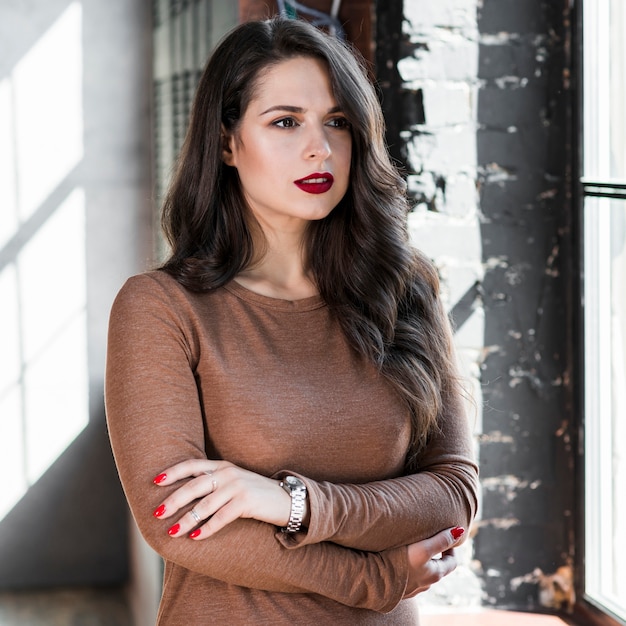 Confident young woman with her arms crossed looking away