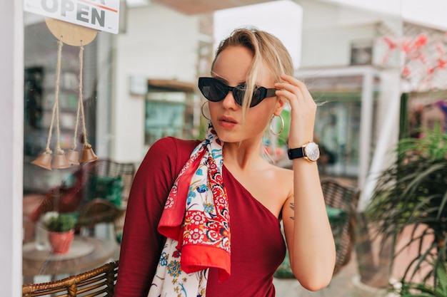 Confident young woman with a lovely sense of humour standing against a shopping mall