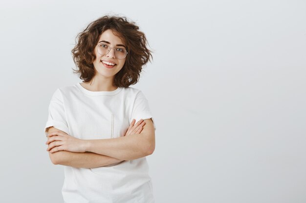 Confident young woman working in team, cross arms chest and smiling satisfied