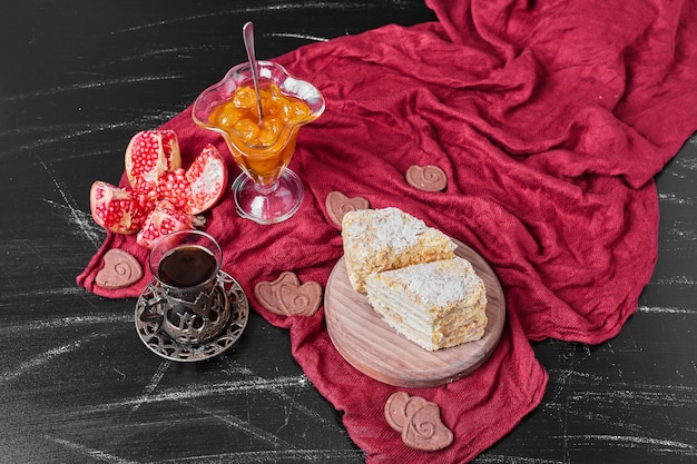 Free photo confiture and cake slices on red towel with tea