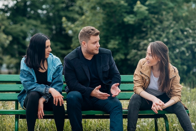 Conflicting people sitting on bench and talking