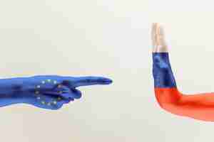 Бесплатное фото Противостояние, разногласия стран. женские и мужские руки окрашены в флаги европейского единства и россии, изолированные на сером фоне. понятие политической, экономической или социальной агрессии.
