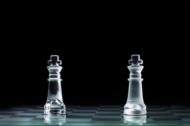 Confrontation - two wooden chess king standing against each other on a chessboard.