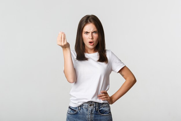 Confused and angry brunette girl arguing about money.