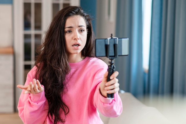 Confused blogger recording herself with smartphone