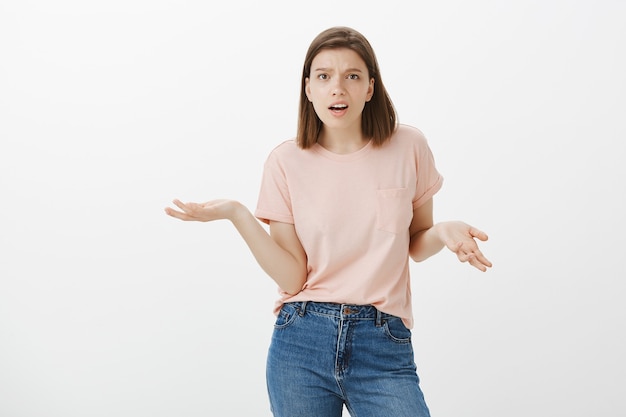 Confused and bothered woman can't understand, asking what, shrugging frustrated