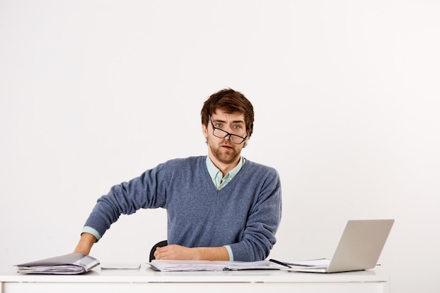 Free photo confused businessman sitting at the office desk