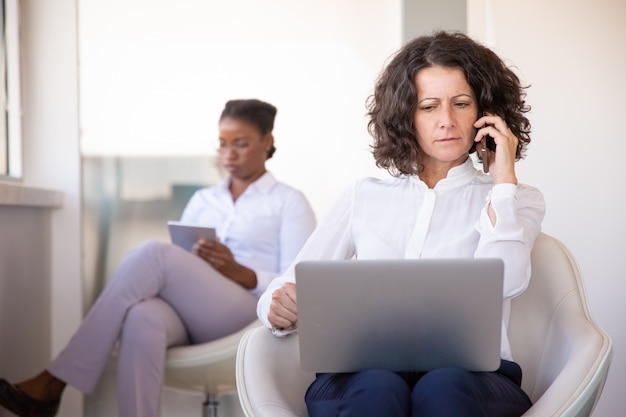 Confused businesswoman talking on phone